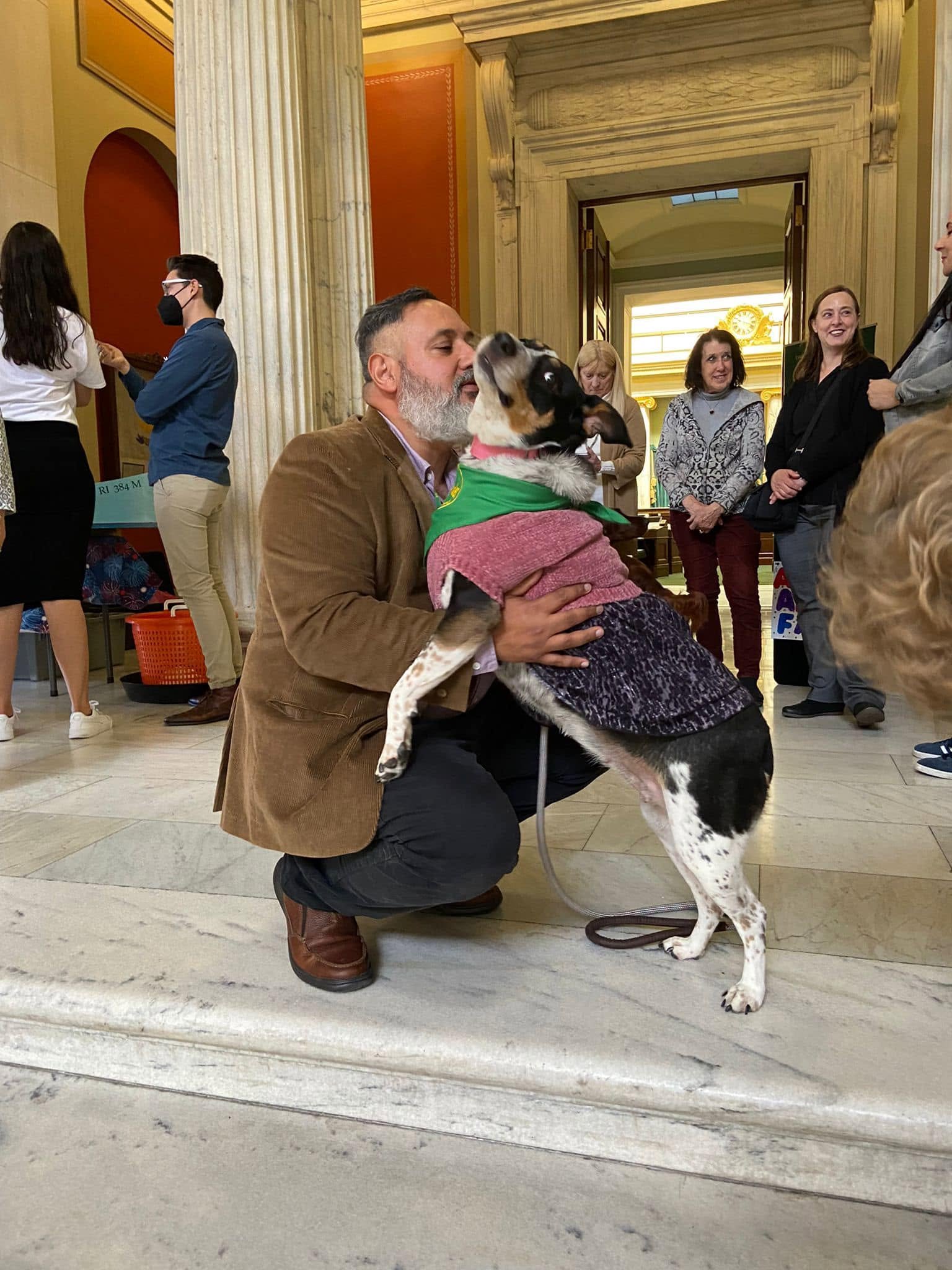 Carlos Moriella greeting Mia during a pet-assisted activity gathering
