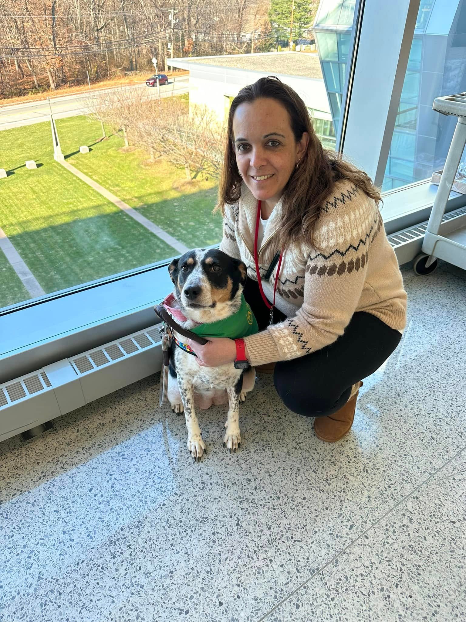 July DeSousa standing outdoors beside a dog