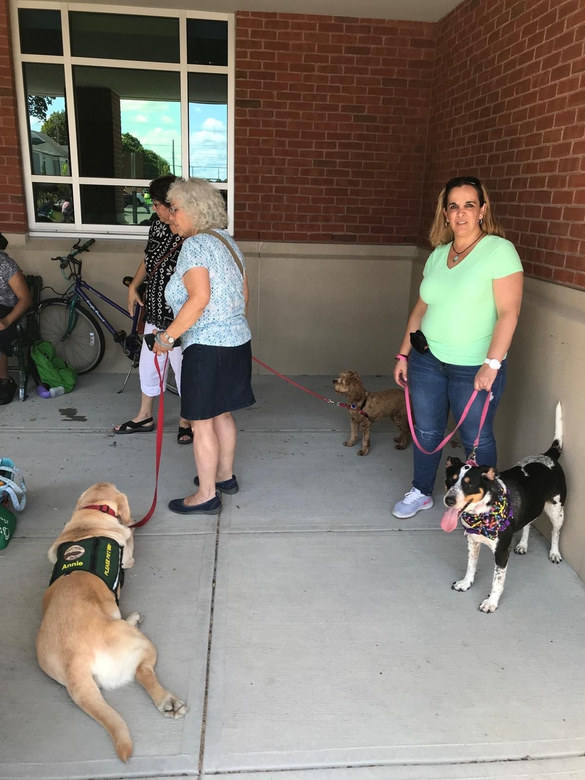 People and dogs gathering at the entrance to a community venue in Pawtucket